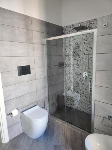 a bathroom with a toilet and a glass shower at Gradini Partenopei in Naples