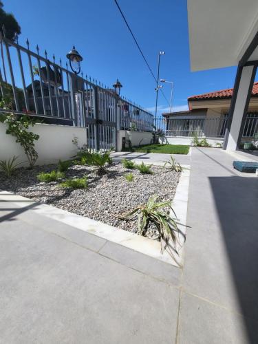 a garden in front of a building with a fence at Lulubay Rooms & Suites in Kusadası