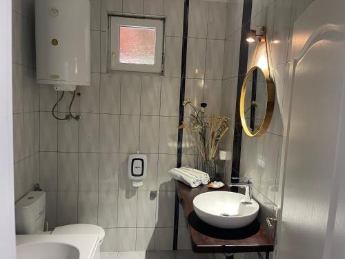bagno con lavandino, servizi igienici e specchio di Vila Aria 