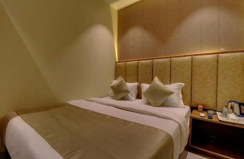 a hotel room with a bed with two pillows at Hotel Amber Suite Near Mumbai Airport in Mumbai