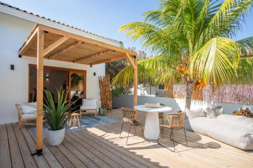 a patio with a couch and a table on a deck at Appartement Joshua in Jan Thiel