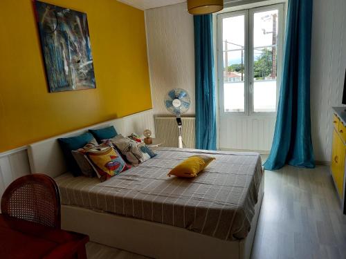 um quarto com uma cama com uma parede amarela em Maison Coquelicot em Saint-Georges-du-Bois