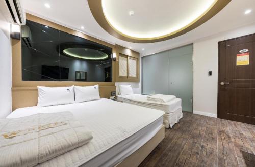 ein Schlafzimmer mit einem großen weißen Bett und einer runden Decke in der Unterkunft Hotel Lien in Busan