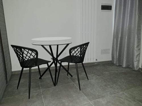 1 mesa y 2 sillas en una habitación en Alloggiamo en Módena