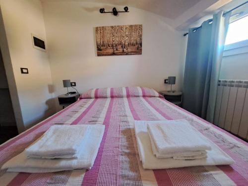 una camera da letto con un letto e due asciugamani di Alloggiamo a Modena