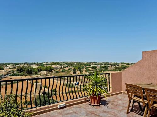 a balcony with a table and a view of a city at Peaceful penthouse with views 3 min walk to the beach in Marsaskala