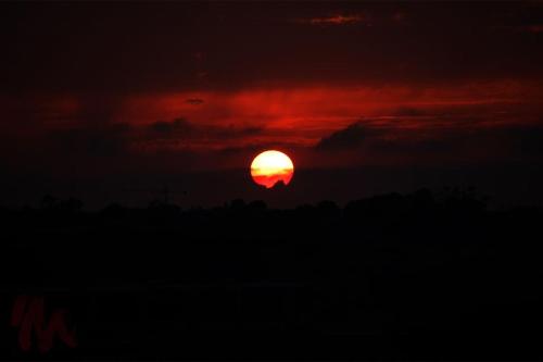 una puesta de sol con el sol en el cielo en Peaceful penthouse with views 3 min walk to the beach en Marsaskala