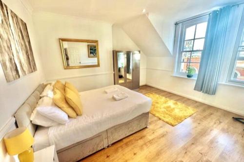 1 dormitorio con 1 cama blanca grande con almohadas amarillas en Roof Terrace Two Bedroom Apartment - Walk to Beach, en Bournemouth