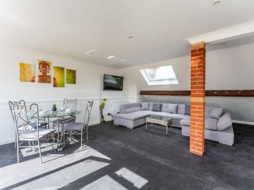 a living room with a couch and a table and chairs at Roof Terrace Two Bedroom Apartment - Walk to Beach in Bournemouth
