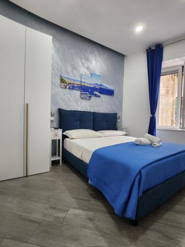 ein Schlafzimmer mit einem Bett und einer blau-weißen Wand in der Unterkunft Gradini Partenopei in Neapel