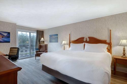 een hotelkamer met een bed en een balkon bij Days Inn by Wyndham Edmundston in Edmundston