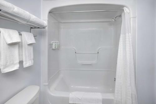 a white bathroom with a tub and a toilet at Days Inn by Wyndham Edmundston in Edmundston