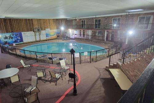 a large pool with tables and chairs in a building at Ramada by Wyndham Mountain Home in Mountain Home