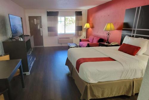 a hotel room with a large bed and a couch at Ramada by Wyndham Mountain Home in Mountain Home