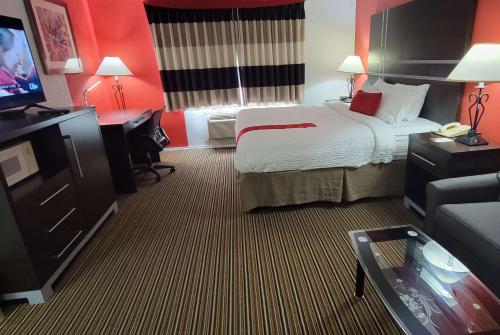 a hotel room with a bed and a flat screen tv at Ramada by Wyndham Mountain Home in Mountain Home