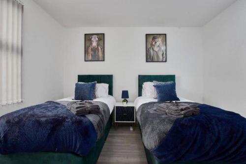 duas camas sentadas uma ao lado da outra num quarto em The Stunning Central Rugby Gem - Sleeps 10 em Rugby