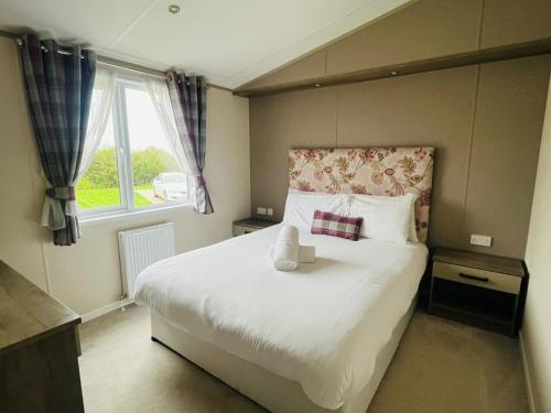 a bedroom with a bed with a teddy bear on it at Springwell Lodge With Hot Tub in Malton