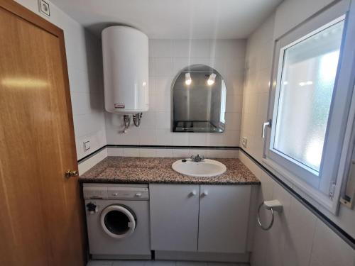 uma casa de banho com um lavatório e uma máquina de lavar roupa em Apartamento Llançà, 2 dormitorios, 5 personas - ES-89-119 em Llançà