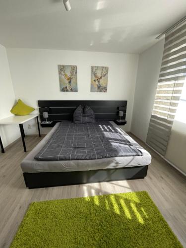 Bodos-Auszeit في Weitnau: غرفة نوم بسرير وسجادة خضراء