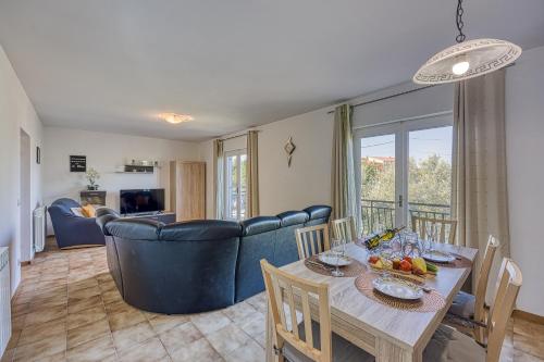a dining room and living room with a table and chairs at Pool House Lilly - Happy Rentals in Višnjan
