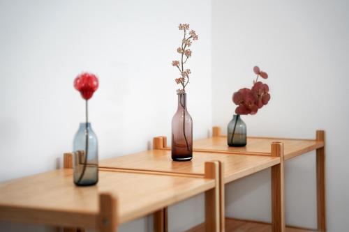 three vases on wooden tables with flowers in them at easy flat Villach main plaza in Villach