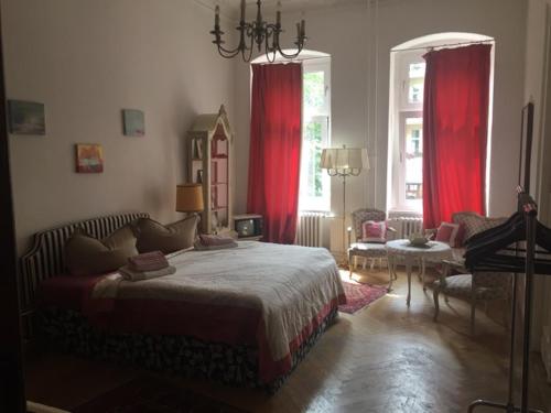 a bedroom with a large bed and red curtains at Kant in Berlin
