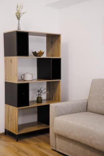a book shelf in a living room next to a couch at easy flat Villach main plaza in Villach