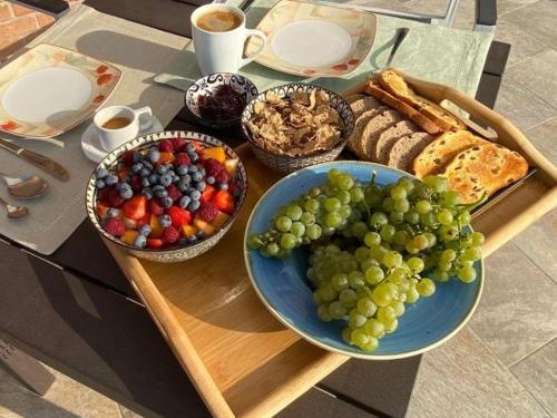 un tavolo ricoperto di ciotole di uva e pane di Da Elvira a Costigliole dʼAsti