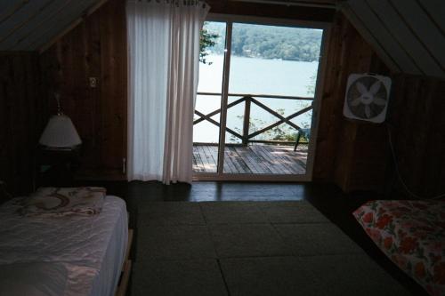 1 dormitorio con ventana y vistas al agua en Cabin A-frame - Beautiful Cabin in Laurel Island, en East Hampton
