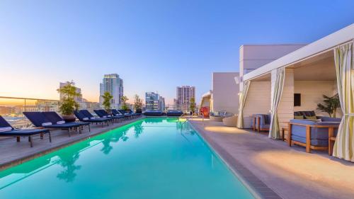 a pool on the rooftop of a building with chairs at Andaz San Diego - a Concept by Hyatt in San Diego