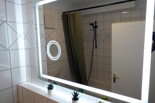 een badkamer met een spiegel en een douche bij Stilvolles Design Apartment mit Rheinblick inkl Netflix & Parkplatz in Düsseldorf
