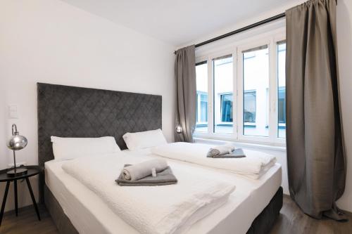 a bedroom with two beds and a large window at easy flat Villach main plaza in Villach