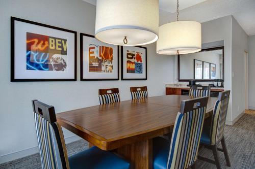 a dining room with a wooden table and chairs at Embassy Suites by Hilton Detroit Metro Airport in Romulus