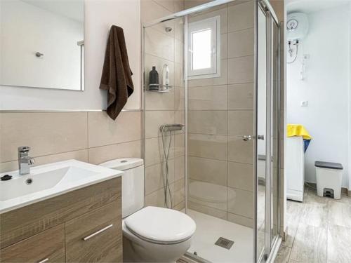 uma casa de banho com um chuveiro, um WC e um lavatório. em Beachfront Apartment incl highspeed WIFI em Melenara