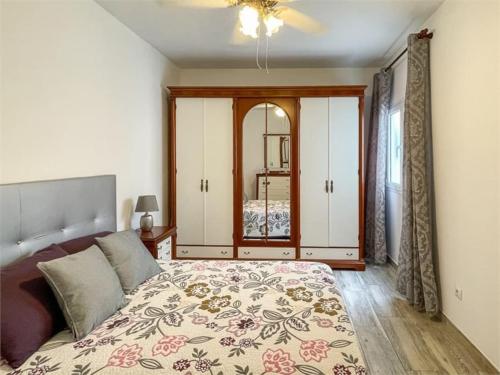 um quarto com uma cama grande e um espelho em Beachfront Apartment incl highspeed WIFI em Melenara