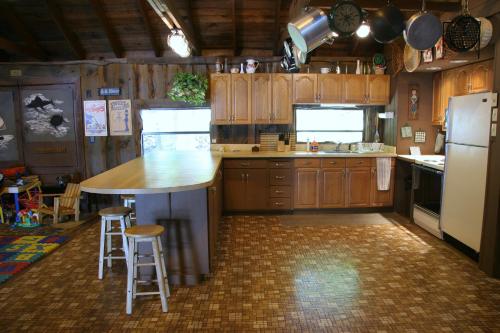 uma cozinha com armários de madeira e uma ilha de cozinha com bancos em Cabin Chalet - Breathtaking Cabin in Laurel Island em East Hampton