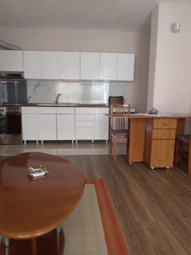 波格拉德茨的住宿－Relax apartament，厨房配有白色橱柜和木桌