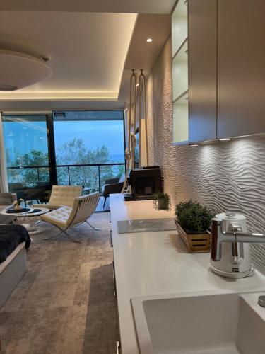 a kitchen with a counter and a living room at Seaside Park apartamenty prywatne z widokiem na morze in Kołobrzeg