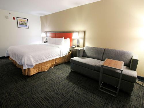 a hotel room with a bed and a couch at Hampton Inn Saint Augustine-I-95 in St. Augustine