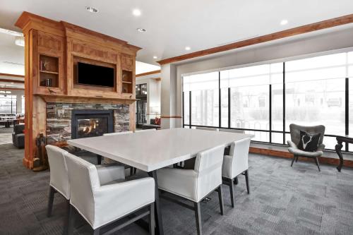 a dining room with a table and chairs and a fireplace at Hilton Garden Inn Missoula in Missoula