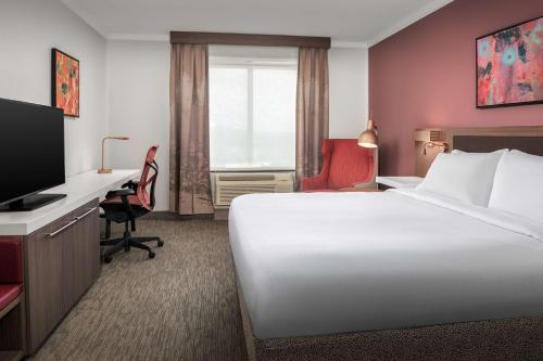 Habitación de hotel con cama, escritorio y TV. en Hilton Garden Inn Missoula en Missoula
