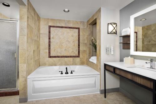 uma casa de banho branca com uma banheira e um lavatório em Hilton Garden Inn Missoula em Missoula