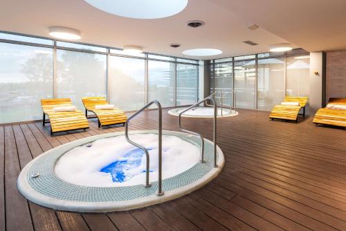 a hot tub in a room with chairs and windows at Hilton Garden Inn Bogota Airport in Bogotá