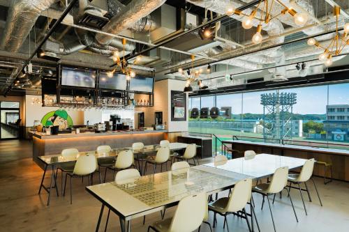 a restaurant with tables and chairs and a bar at SETOUCHI KEIRIN HOTEL 10 by Onko Chishin in Tamano