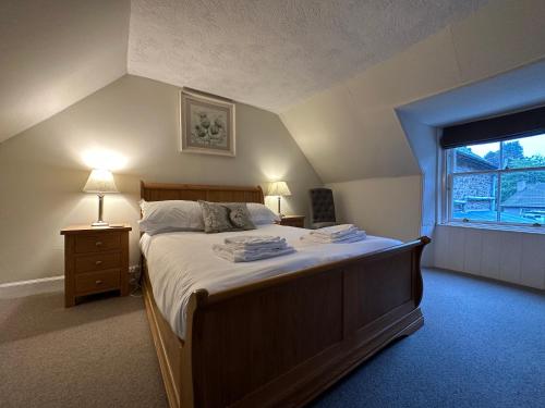 a bedroom with a large bed and a window at Red Squirrel Cottage in Strathtay