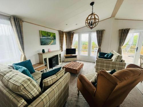 uma sala de estar com dois sofás e uma lareira em Hedgerow Lodge with Hot Tub em Malton