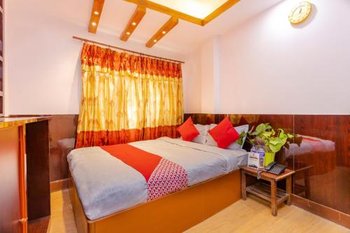 um quarto com uma cama com um cobertor colorido em OYO 800 New Muktinath Hotel em Kathmandu
