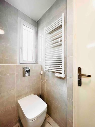 ein Bad mit einem WC und einem Fenster in der Unterkunft 2 chambres proche de transport in La Courneuve