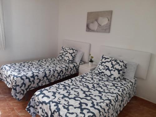 プエルト・デル・カルメンにあるapartamento MAKTUBのベッド2台と椅子が備わる客室です。