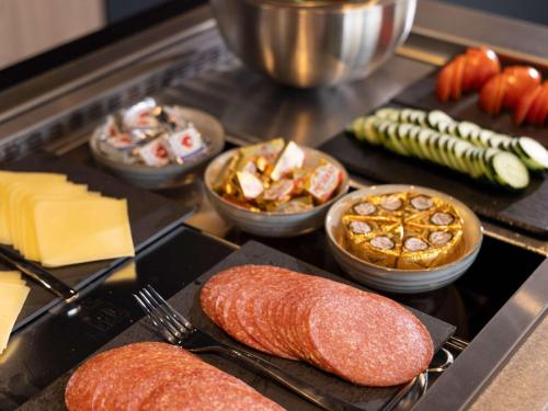 a bunch of different types of food on a stove at Adagio Antwerp City Center in Antwerp